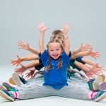 Children sitting down in a row with Jazz hands